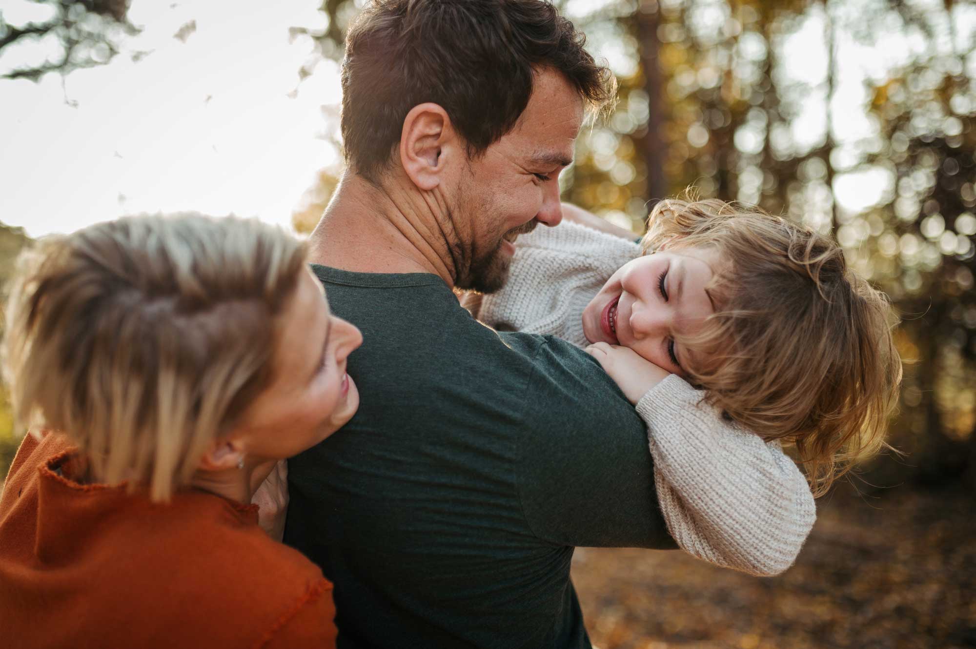father-holding-daughter-with-mom-laughing